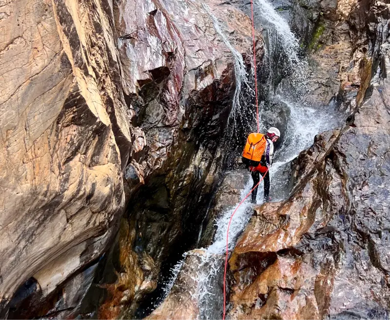 Canyoneur en rappel dans une cascade rocheuse